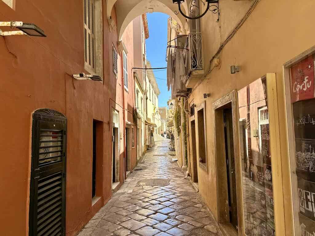 Strada stretta e pittoresca nel centro storico di Corfu Town con edifici colorati