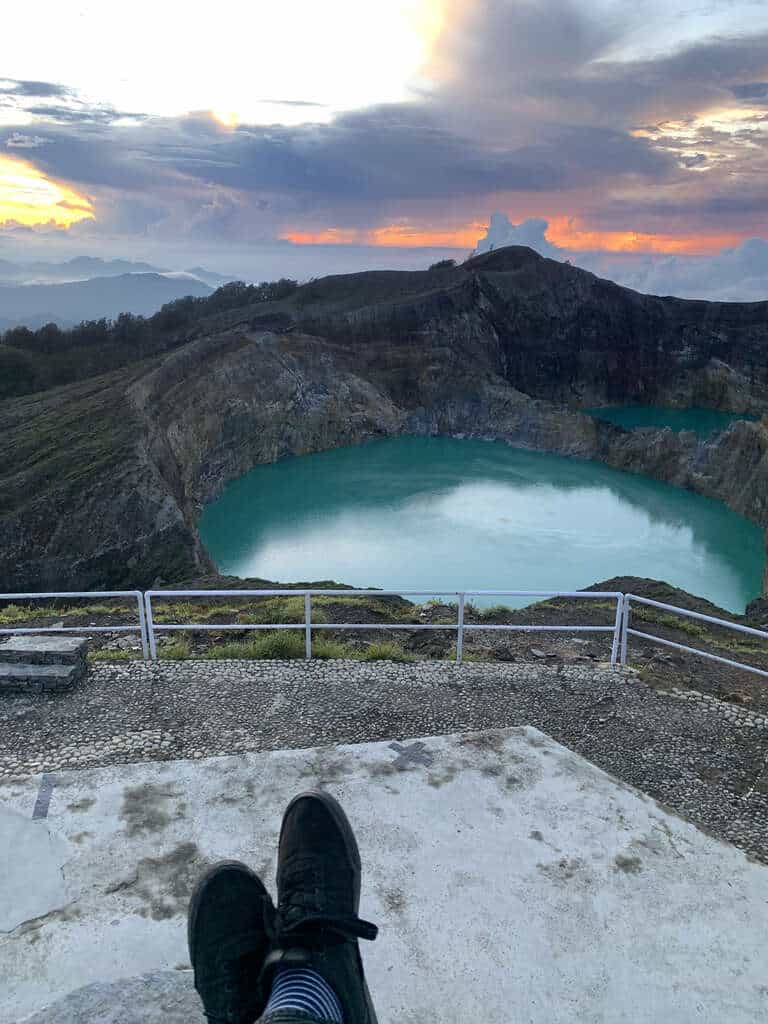 Waiting for sunrise at the Kelimutu viewpoint, feet up on the railing platform