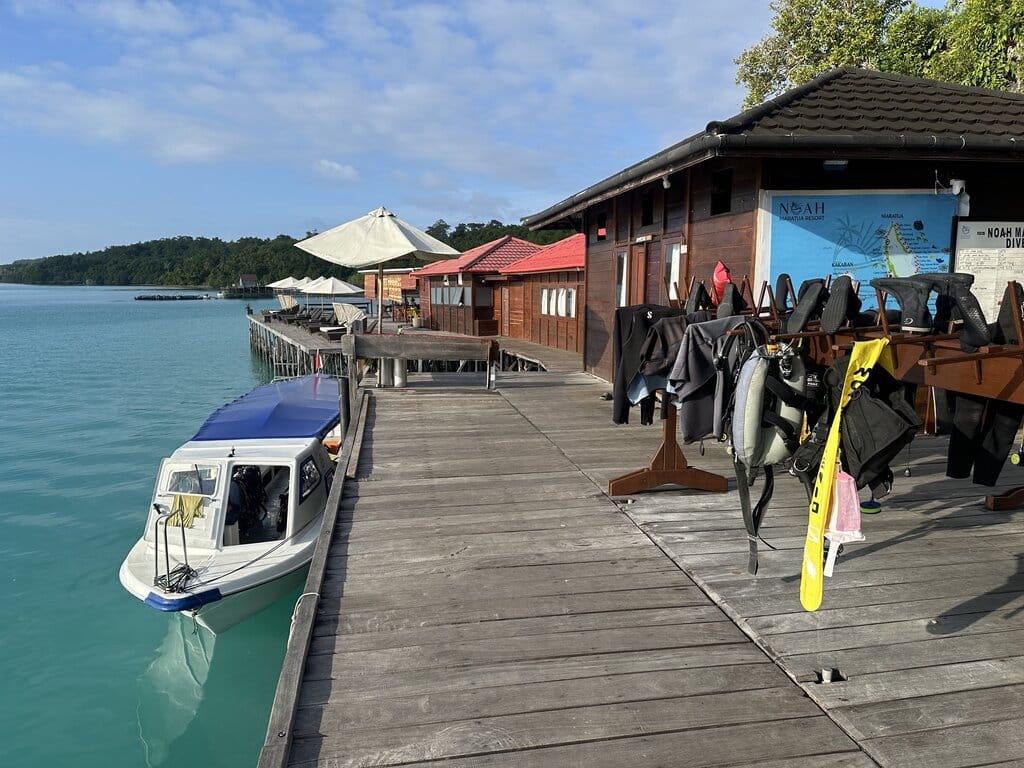 The dive center jetty with gear racks and a boat at Noah Maratua Resort