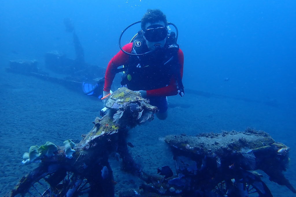 Mergulhador ao lado de uma moto submersa no naufrágio do Boga, Kubu, perto de Tulamben, Bali