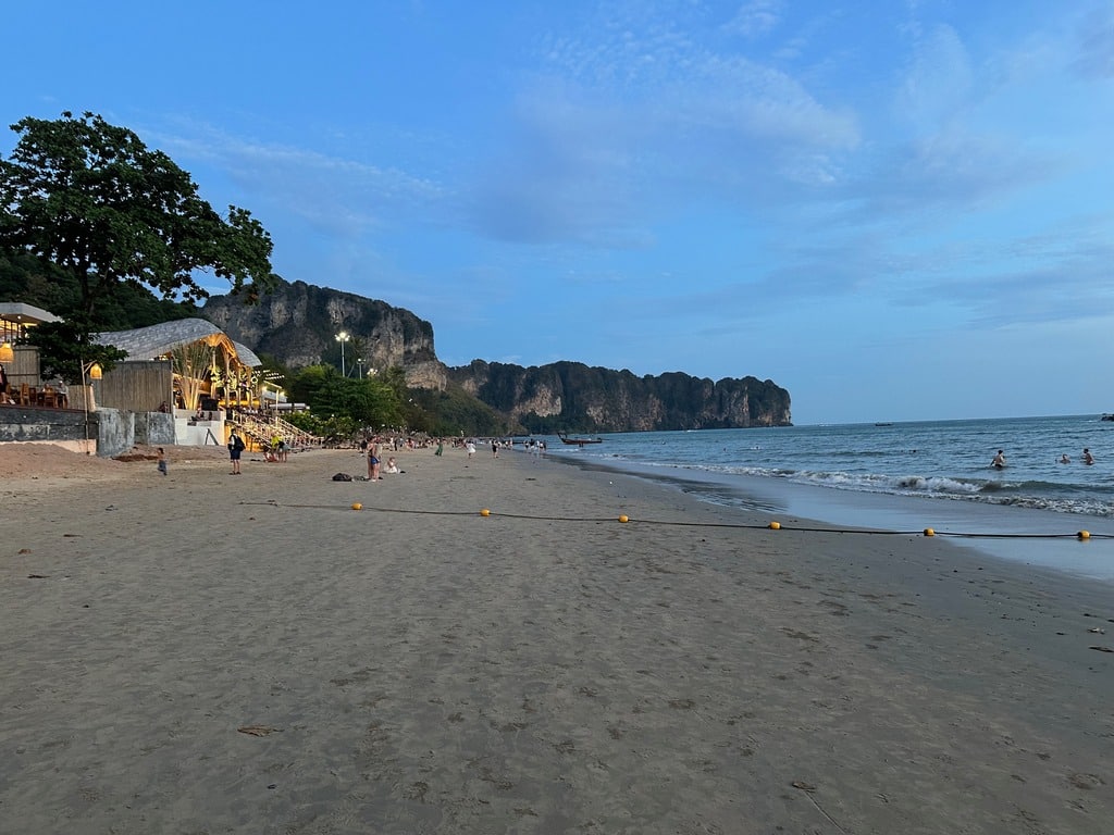 A praia de Ao Nang ao entardecer com o promontório calcário na ponta leste