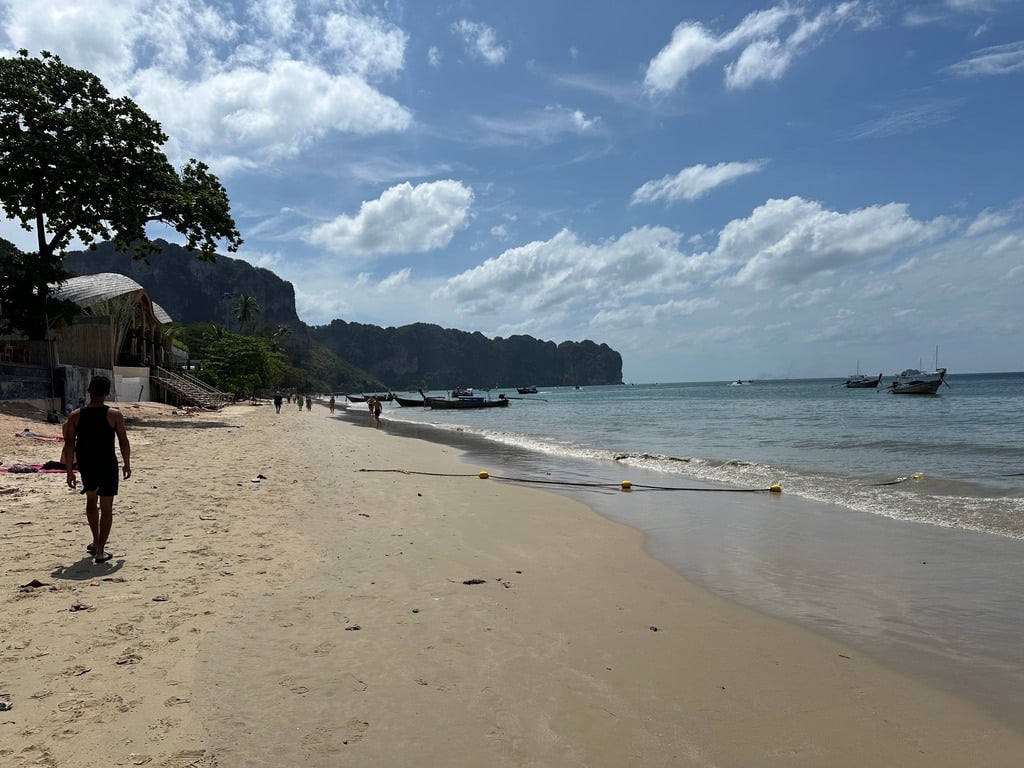 Mit gelben Bojen markierte Badebahn am Ao Nang Beach, dahinter Longtail-Boote