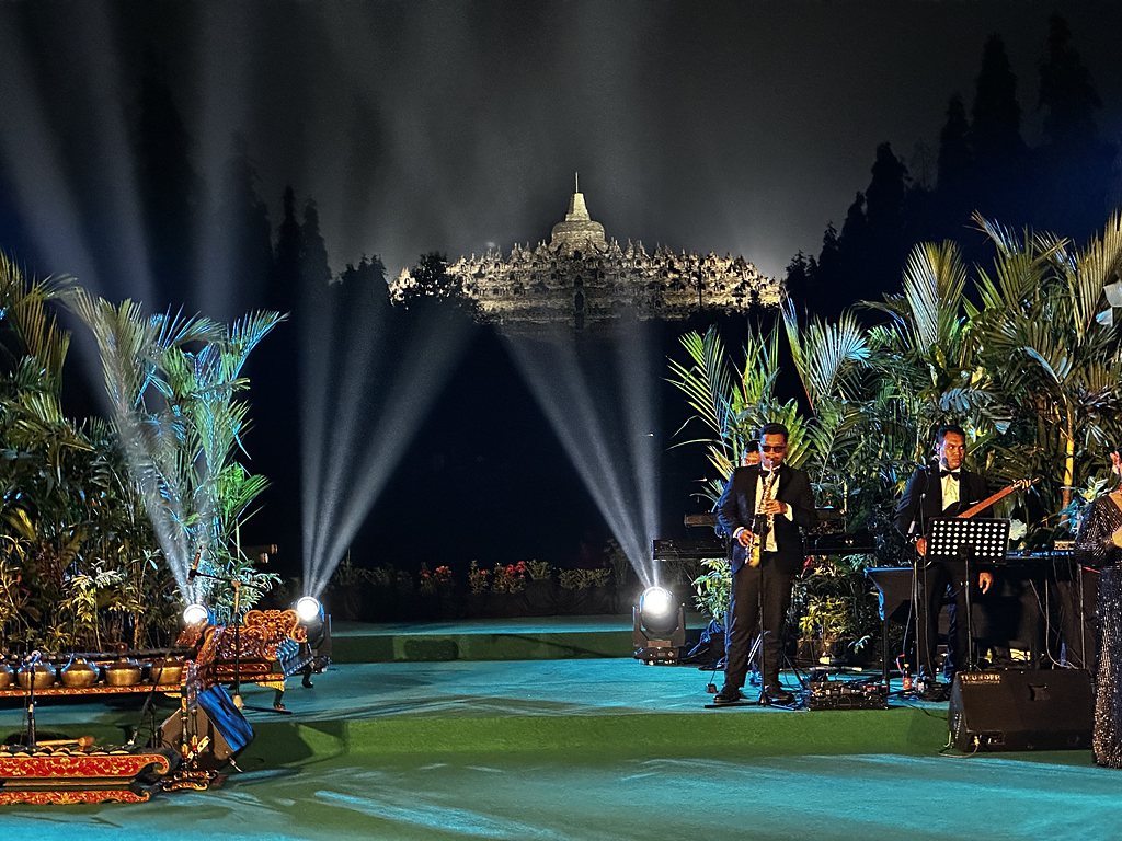 Borobudur temple lit by spotlights at night behind a stage during a private evening event, Java, Indonesia