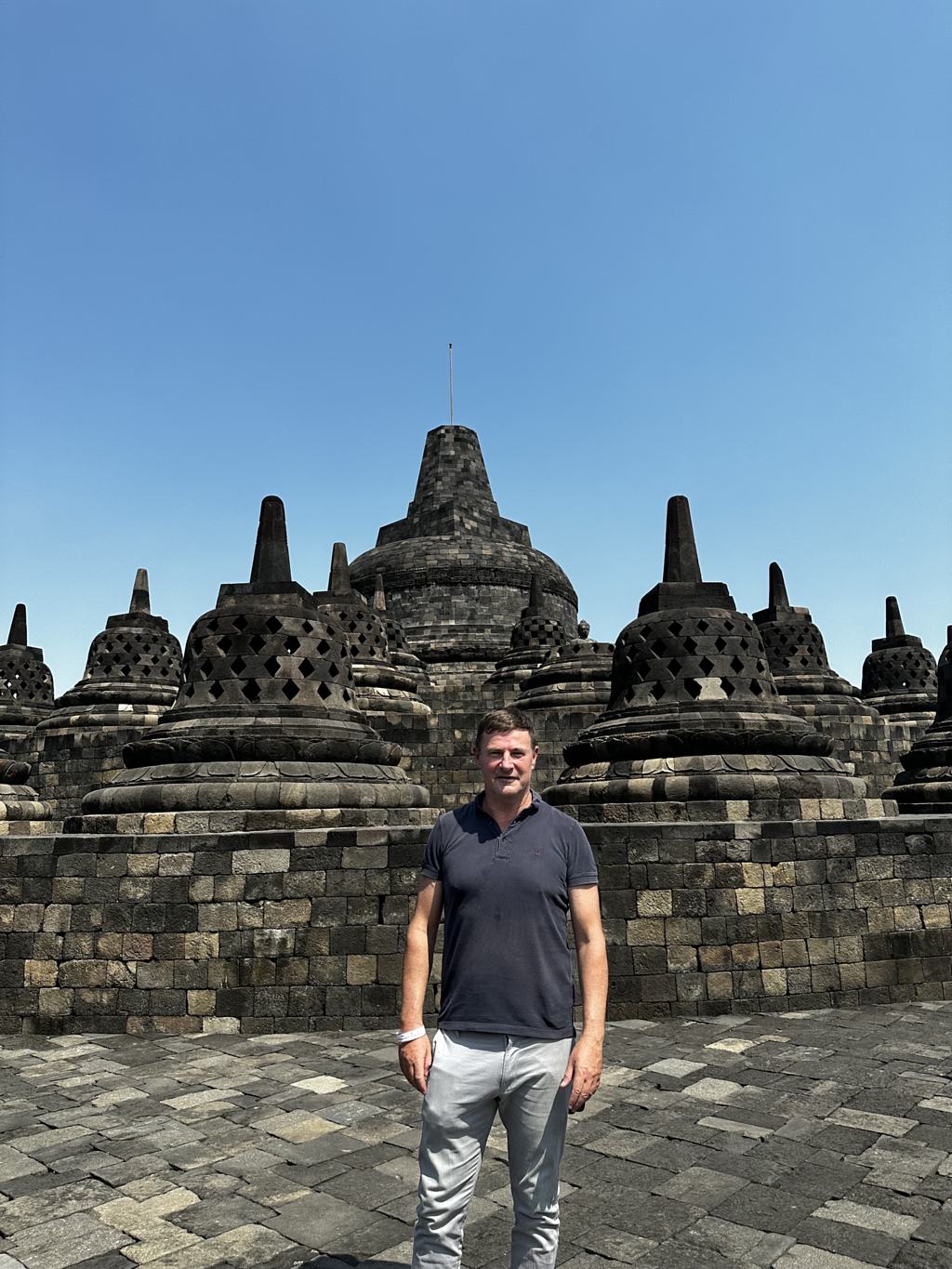 Blaise Jaeger standing on the upper terrace of Borobudur among the bell-shaped stupas, September 2023, Java, Indonesia