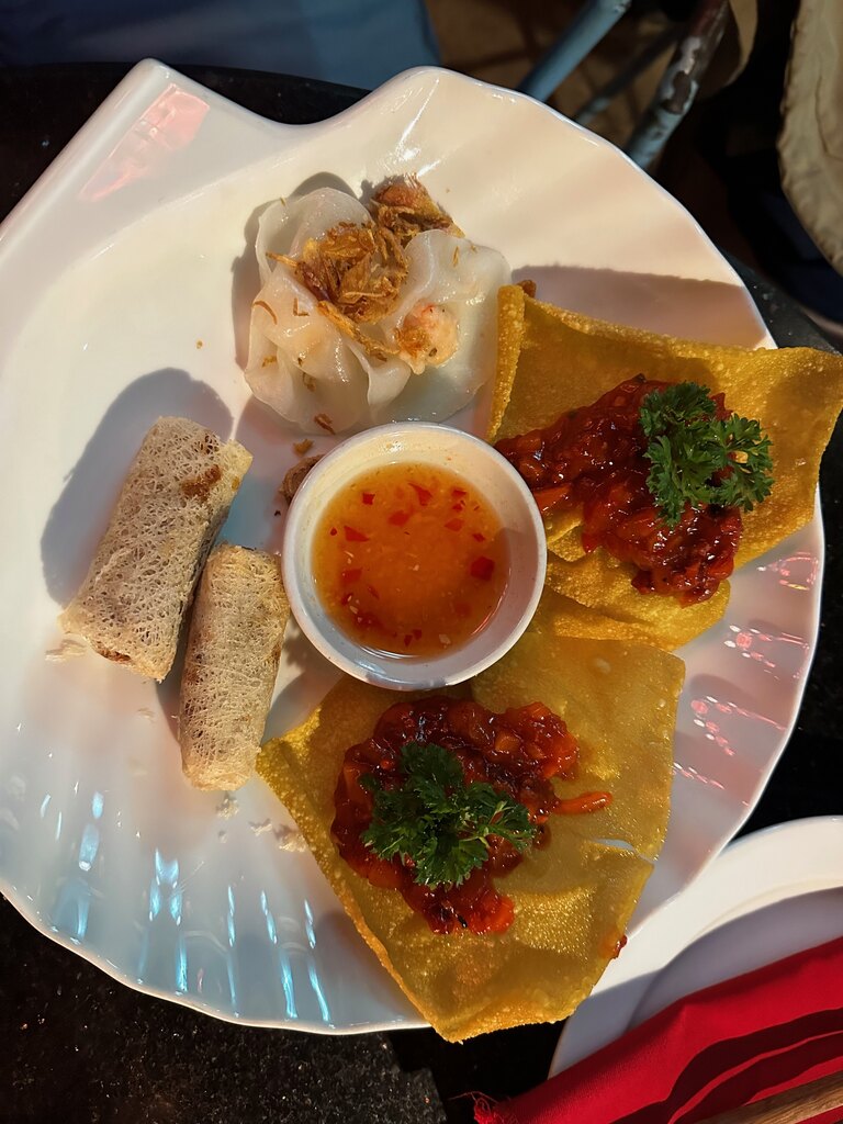 Bord met een witte-roosdumpling met gefrituurde sjalot, gefrituurde wonton met tomatensalsa en loempia's, Hoi An