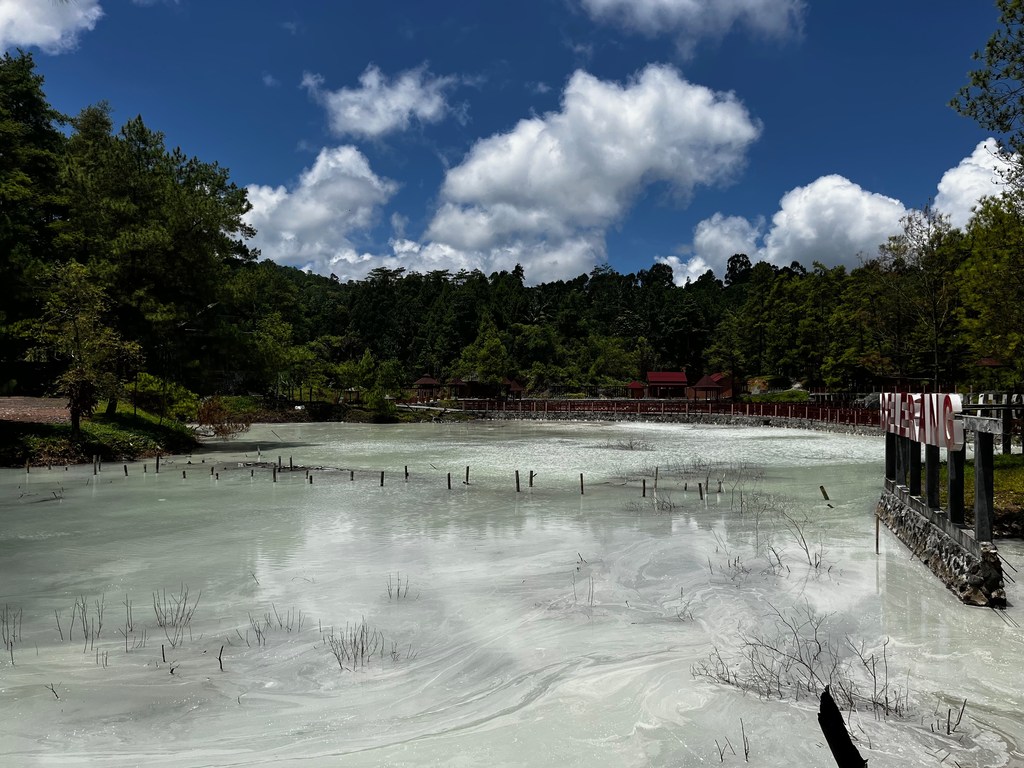 La crosta bianca di zolfo e l'acqua pallida del lago Linow, vicino a Tomohon, Sulawesi del Nord