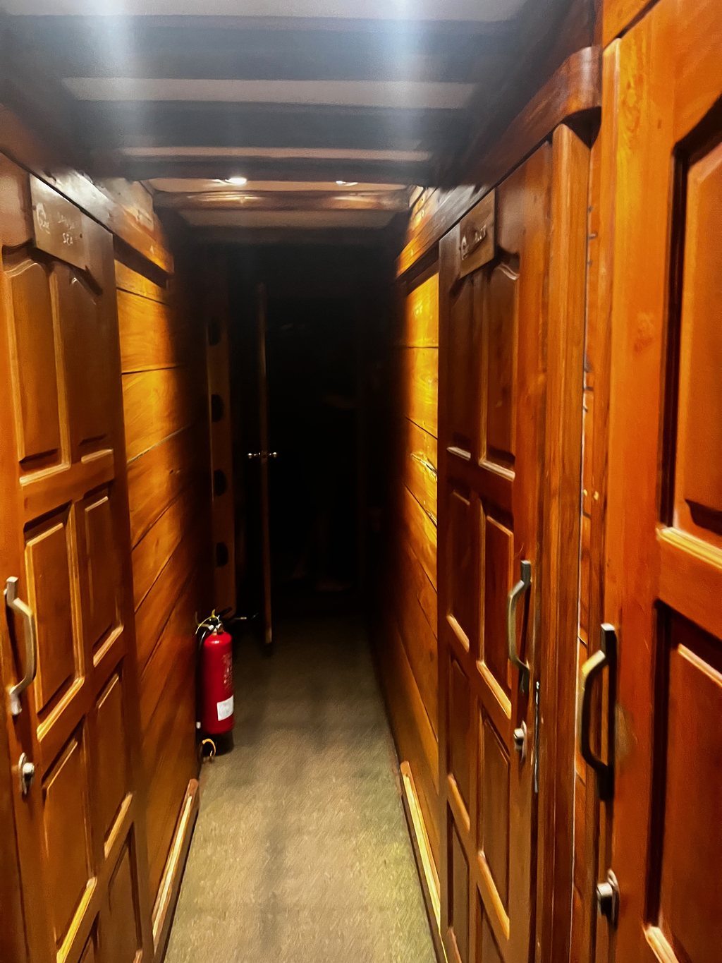 Corridoio di legno e porte delle cabine sottocoperta su una liveaboard phinisi indonesiana