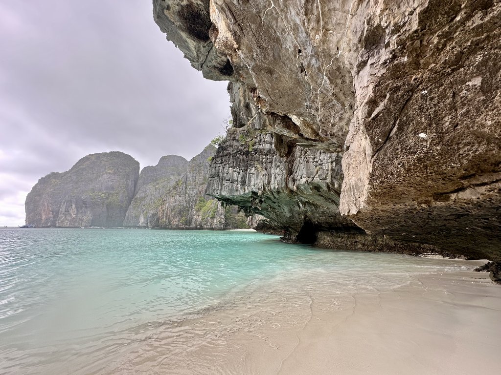 Felsüberhang und flaches Wasser am Rand von Maya Bay