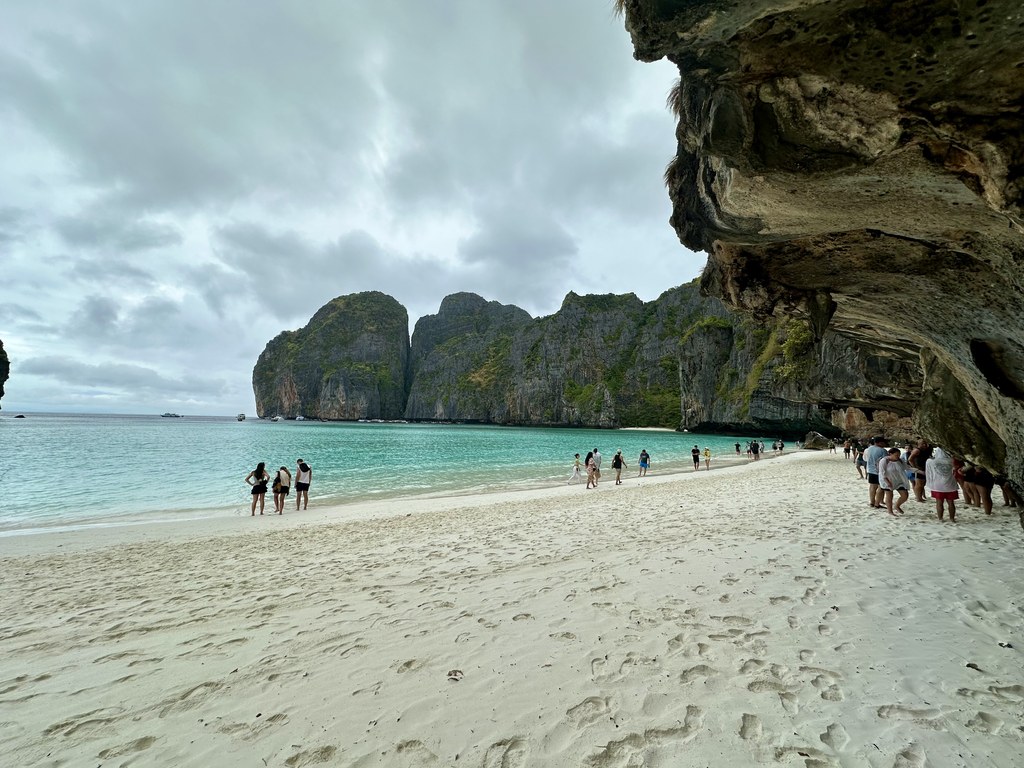 Besucher auf dem Sand von Maya Bay unter den Kalksteinfelsen