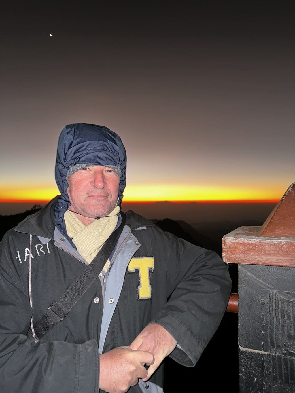 Blaise Jaeger in een gehuurde gewatteerde parka wachtend op de zonsopgang in het donker boven de Tengger-caldera, Mount Bromo