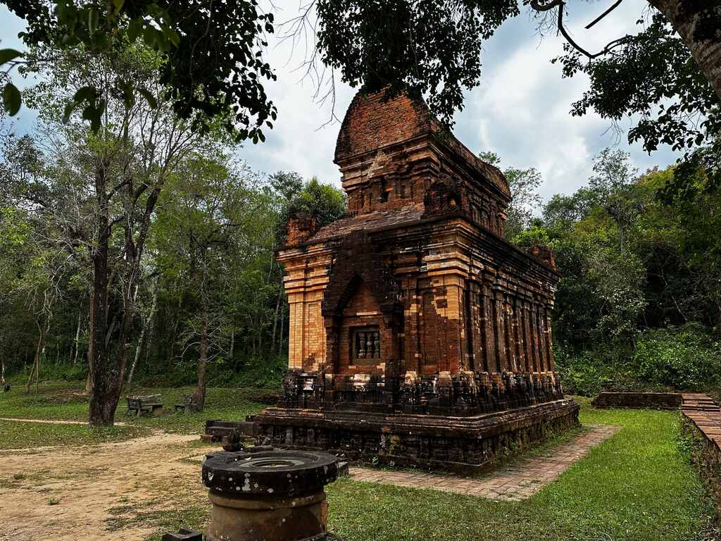 Een volledig bewaarde bakstenen Cham-toren met piramidedak op een open plek in My Son, Vietnam