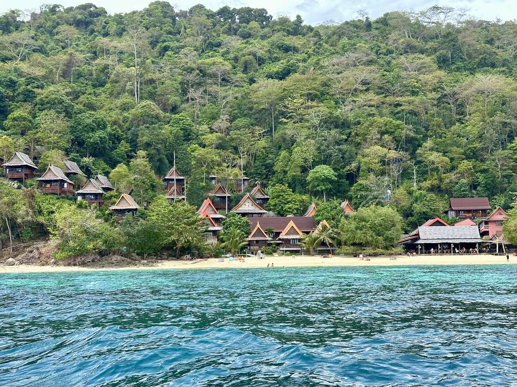 Bangalôs entre as árvores acima da praia de Phak Nam, na tranquila costa sul de Koh Phi Phi Don
