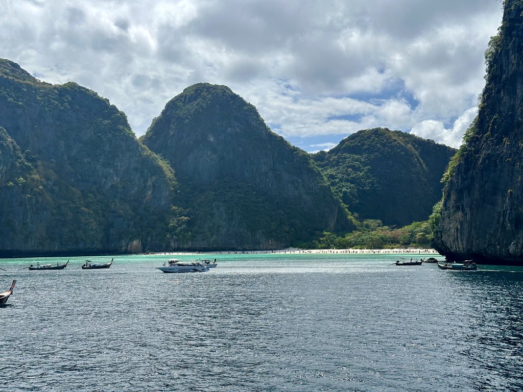 Türkisfarbenes Wasser und Longtailboote unter den Felsen von Phi Phi Leh