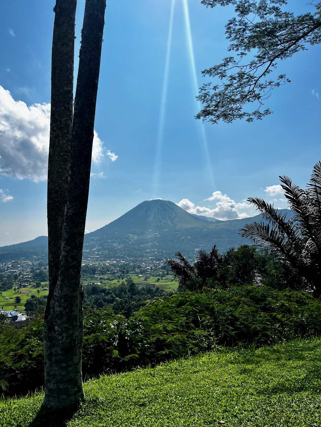 Un vulcano che si alza dietro gli alberi sugli altipiani Minahasa, vicino a Tomohon, Sulawesi