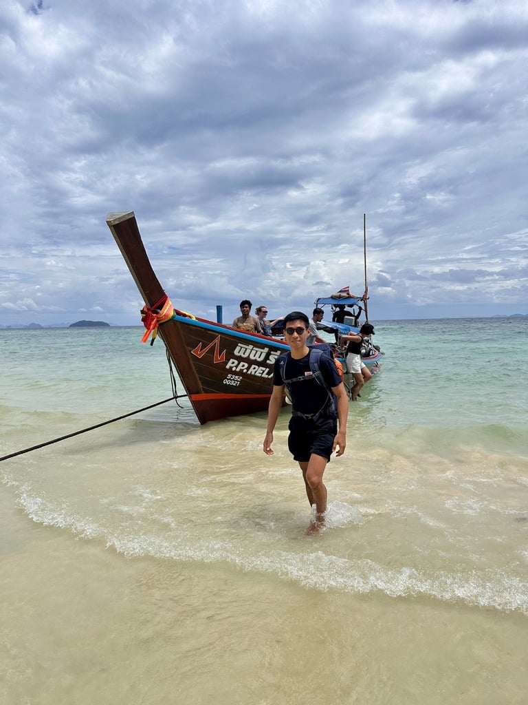 Aussteigen aus einem Longtailboot auf den Sand von Koh Phi Phi Don