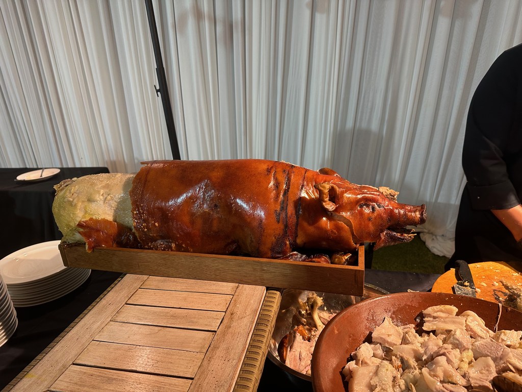 Babi guling, balinesisches Spanferkel vom Spieß, bei einer Feier tranchiert