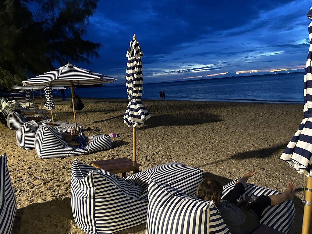 Bar de praia com pufes na areia ao entardecer em Koh Lanta