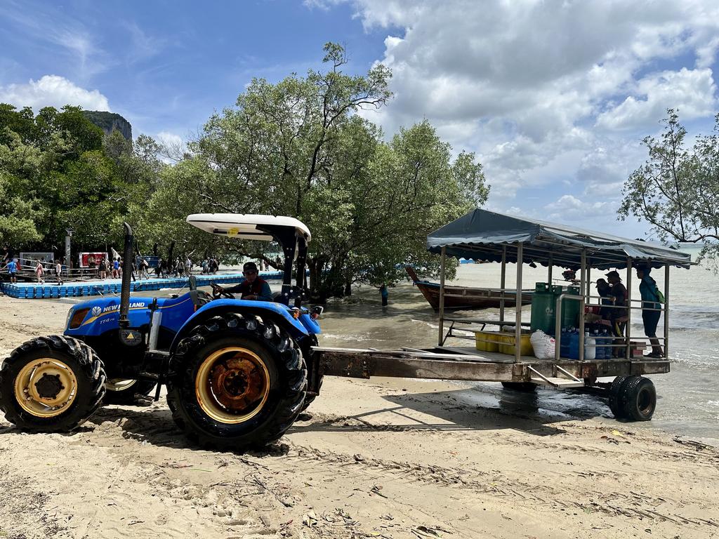Blauer Traktor mit Anhänger im Sand von Railay East, die einzigen Fahrzeuge der Halbinsel