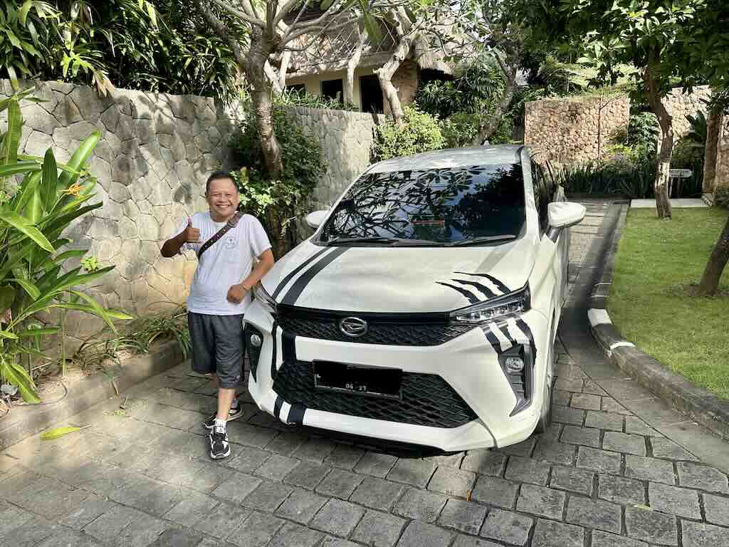 Easy Journey Bali のバリ島専属ドライバー Ali、自分の車の横に立つ