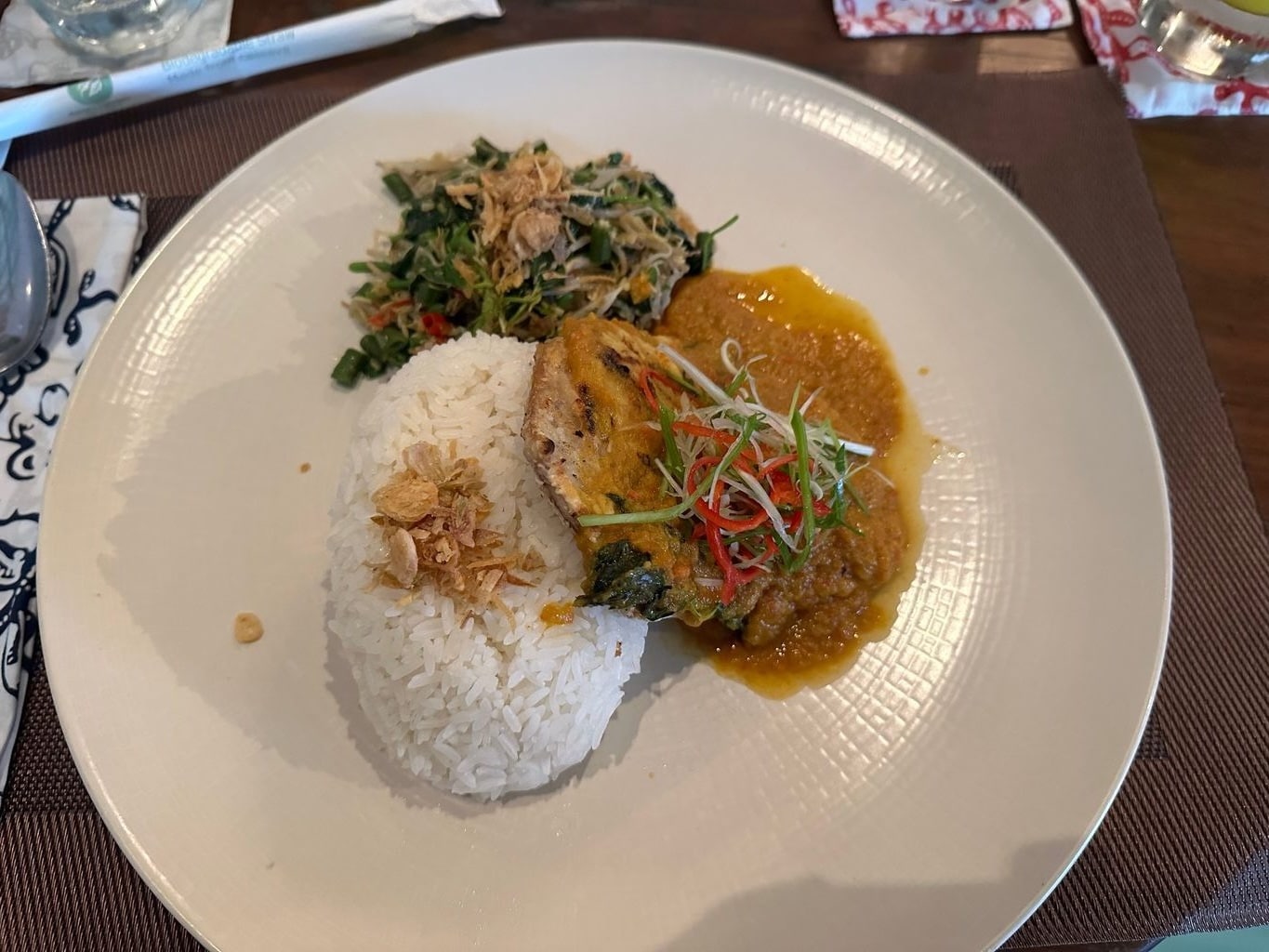Fisch in gelbem Kokoscurry mit Reis und urap-Gemüse in einem indonesischen rumah makan