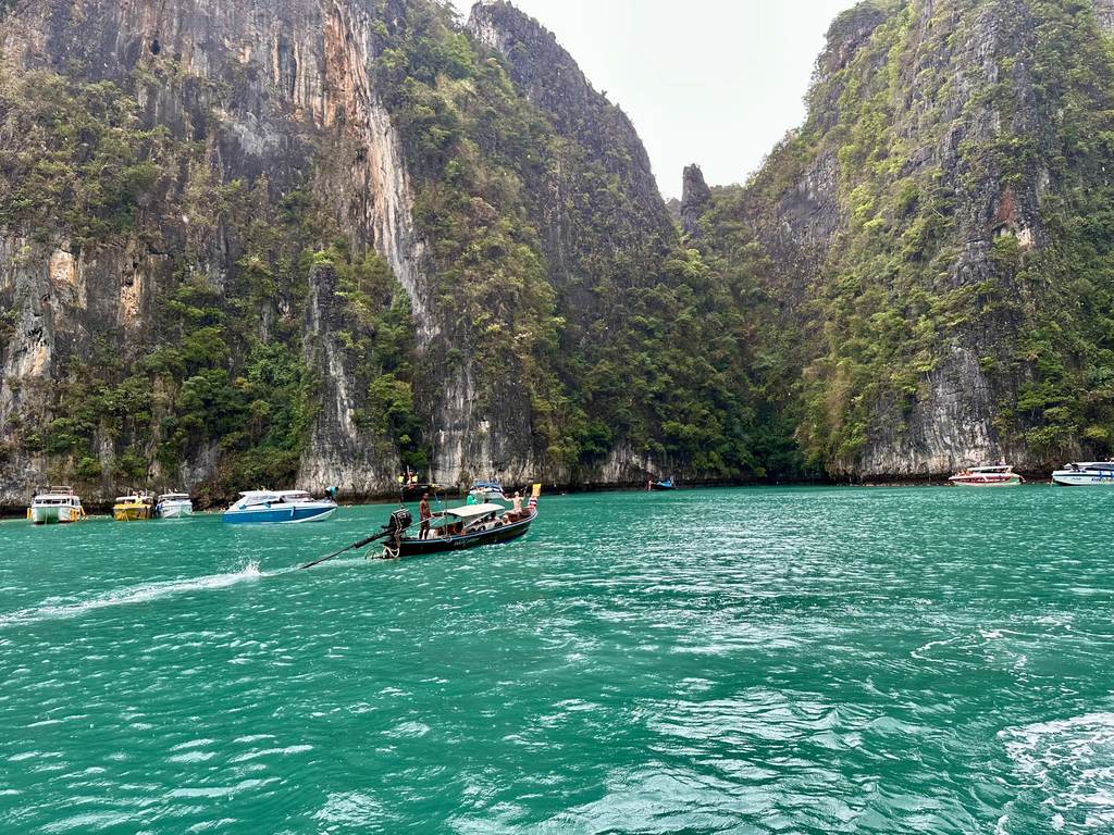 Longtailboote an Bojen in der Pileh Lagoon