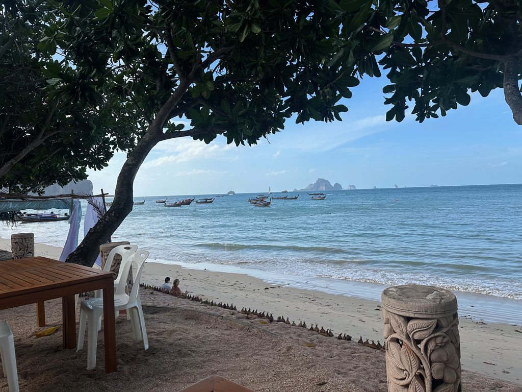Vista matinal da praia de Ao Nang com longtails e as ilhas calcárias ao largo