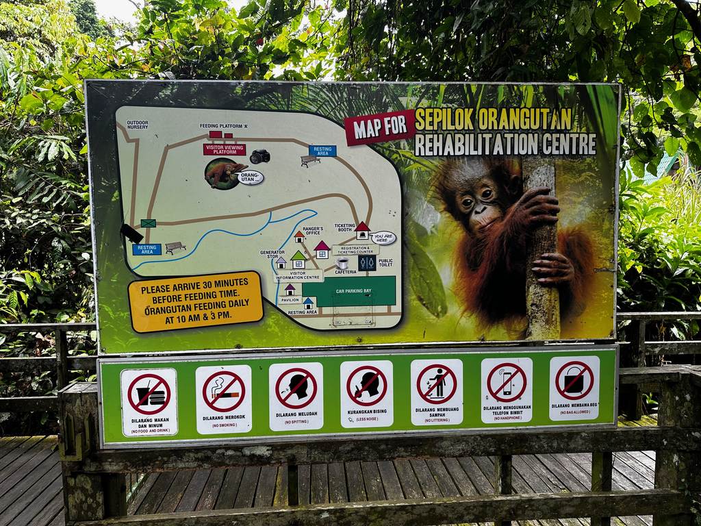 Tafel mit Karte und Fütterungszeiten am Orang-Utan-Rehabilitationszentrum in Sepilok