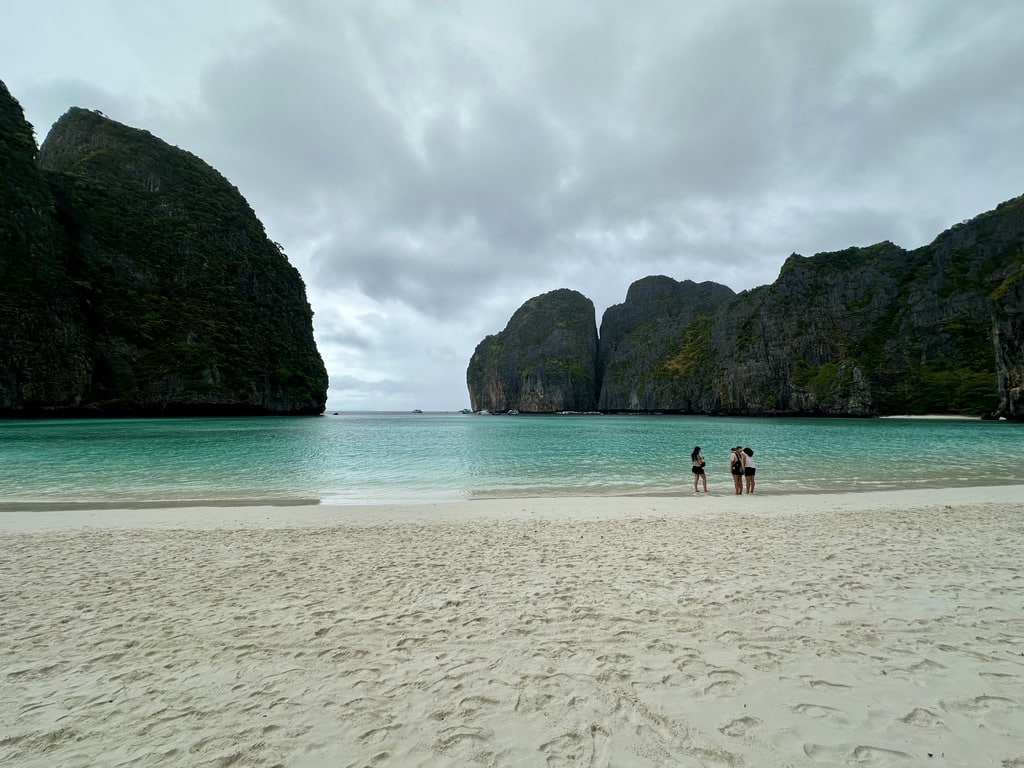 Besucher stehen knietief im Wasser in Maya Bay, wo Schwimmen verboten ist