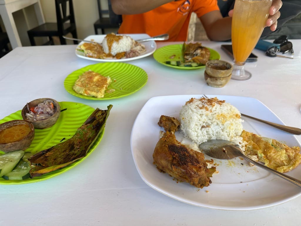 Eine Warung-Mahlzeit mit Reis, Grillhähnchen, Omelett, pepes im Bananenblatt, Gurke und sambal