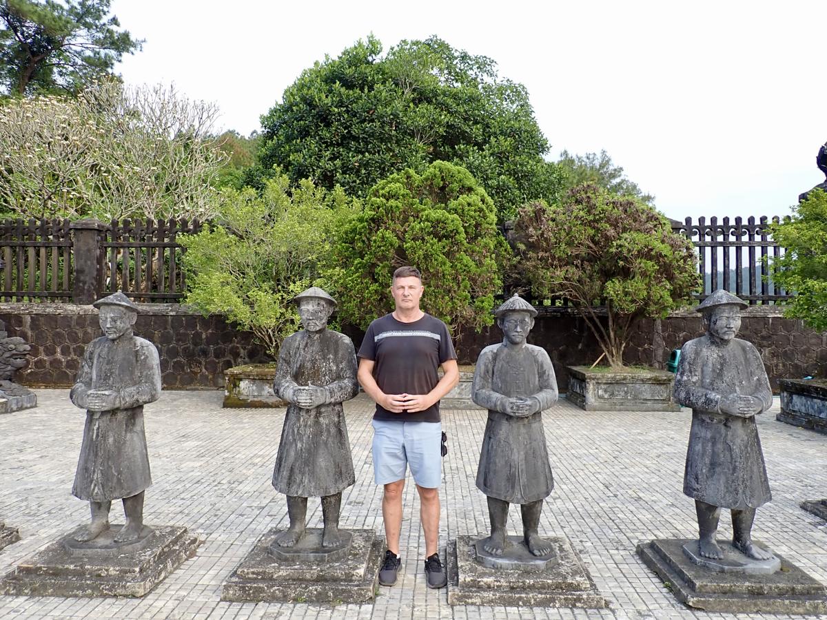 Blaise Jaeger standing among the stone mandarin statues in the honour courtyard of the tomb of Khai Dinh in Hue