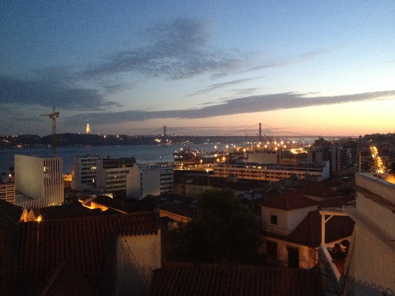 The 25 de Abril Bridge lit up at dusk seen from Santa Catarina