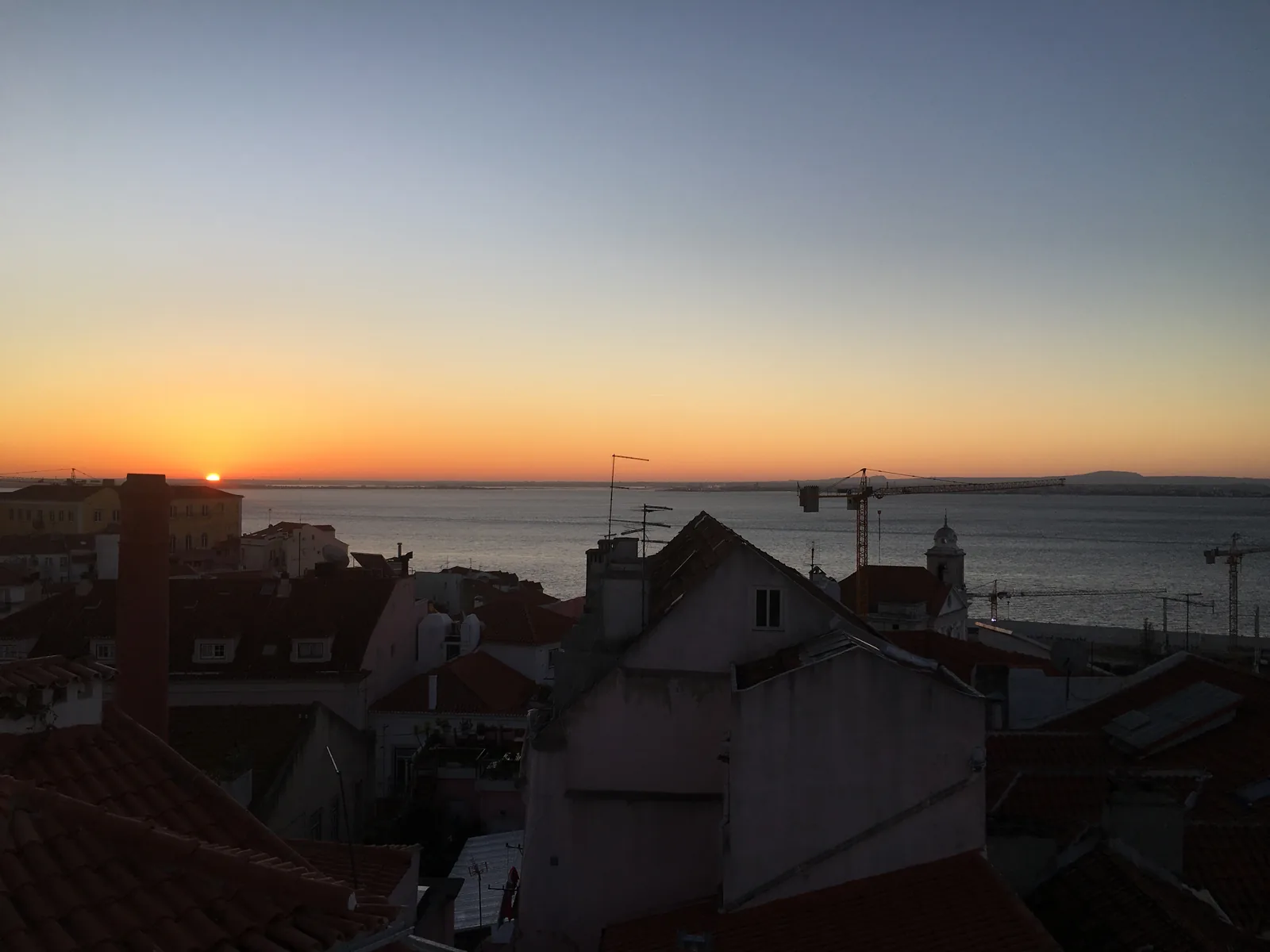 Sunset over the roofs of Alfama and the Tagus in Lisbon