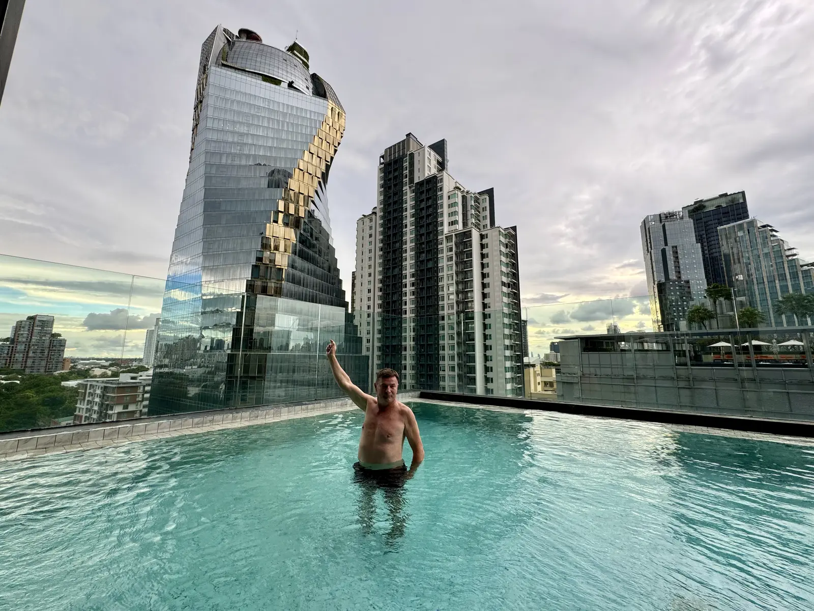 Blaise Jaeger in the rooftop pool of the Ascott Thonglor facing a twisted glass tower, Bangkok