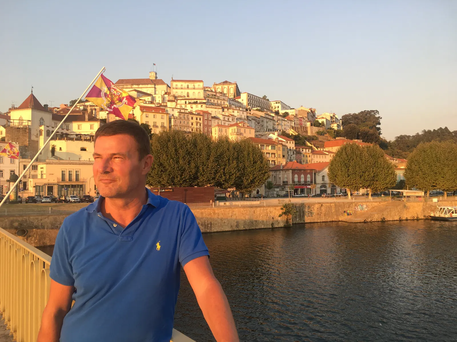Blaise Jaeger on a bridge over the Mondego with the old town of Coimbra behind