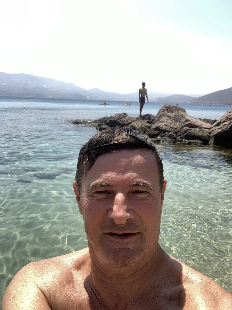 Blaise Jaeger swimming in the clear water of Agios Sostis, Mykonos