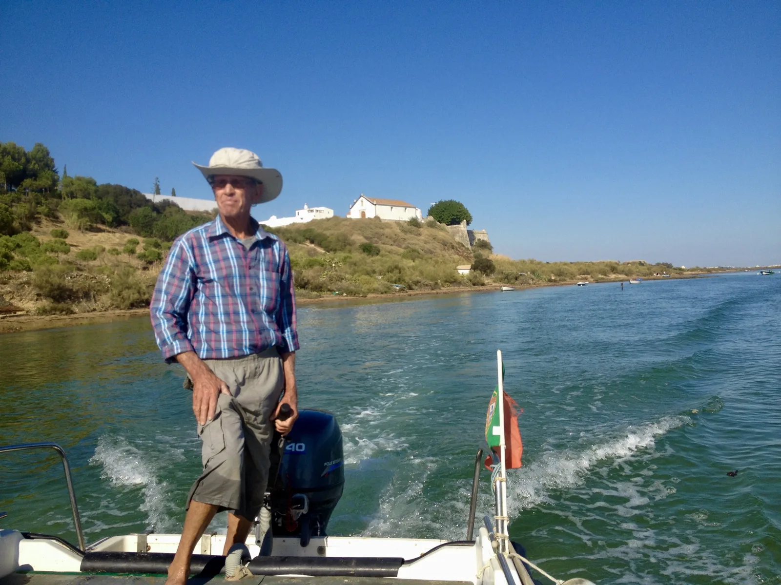 The boatman steering his small boat across the lagoon from Fábrica to the beach