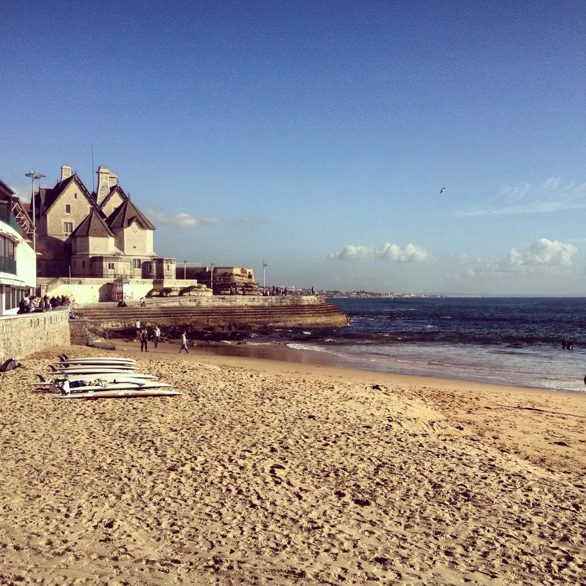 A small sandy beach in the center of Cascais with old villas behind