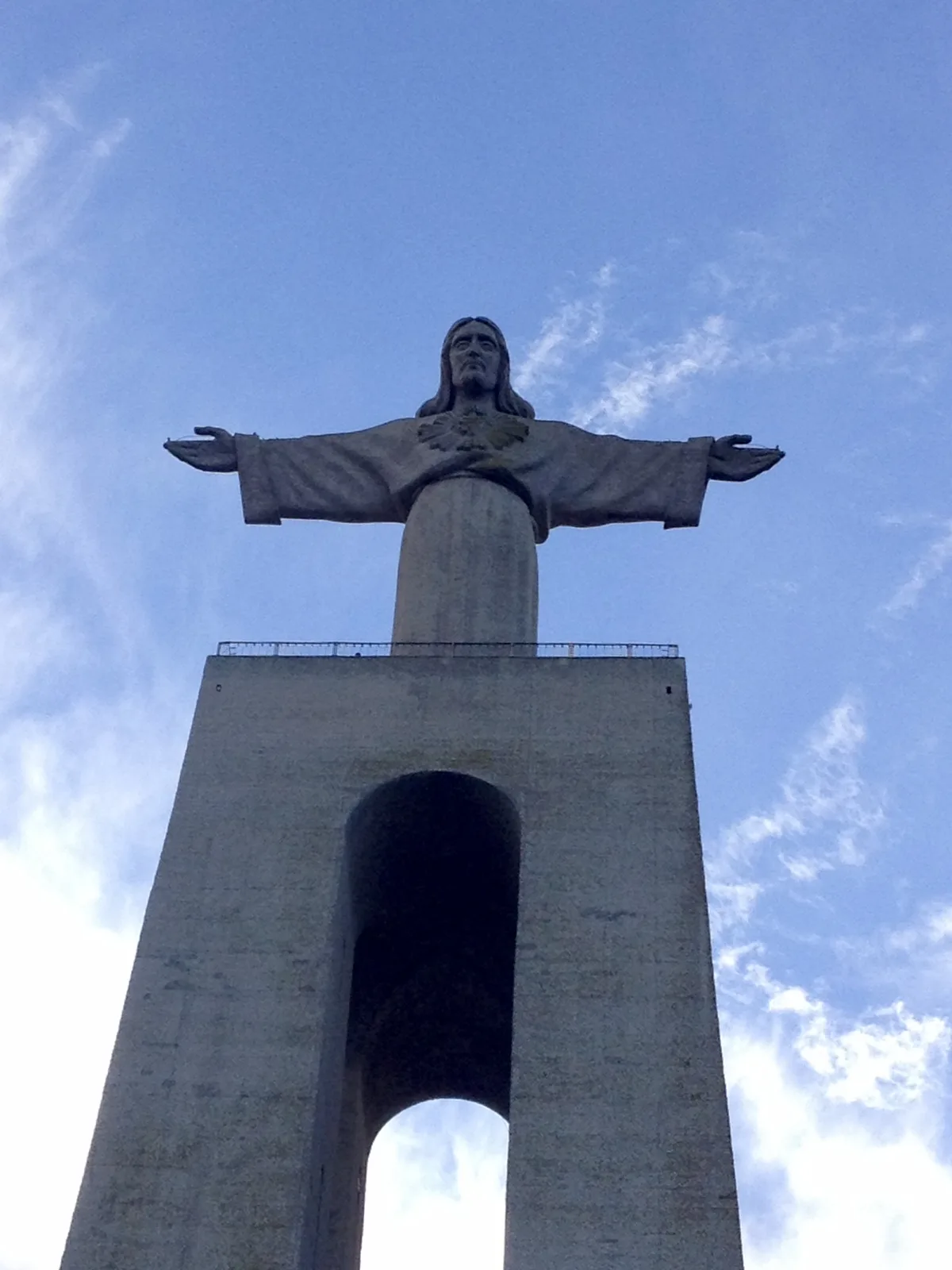 The statue of Christ the King with open arms on its tall pedestal in Almada