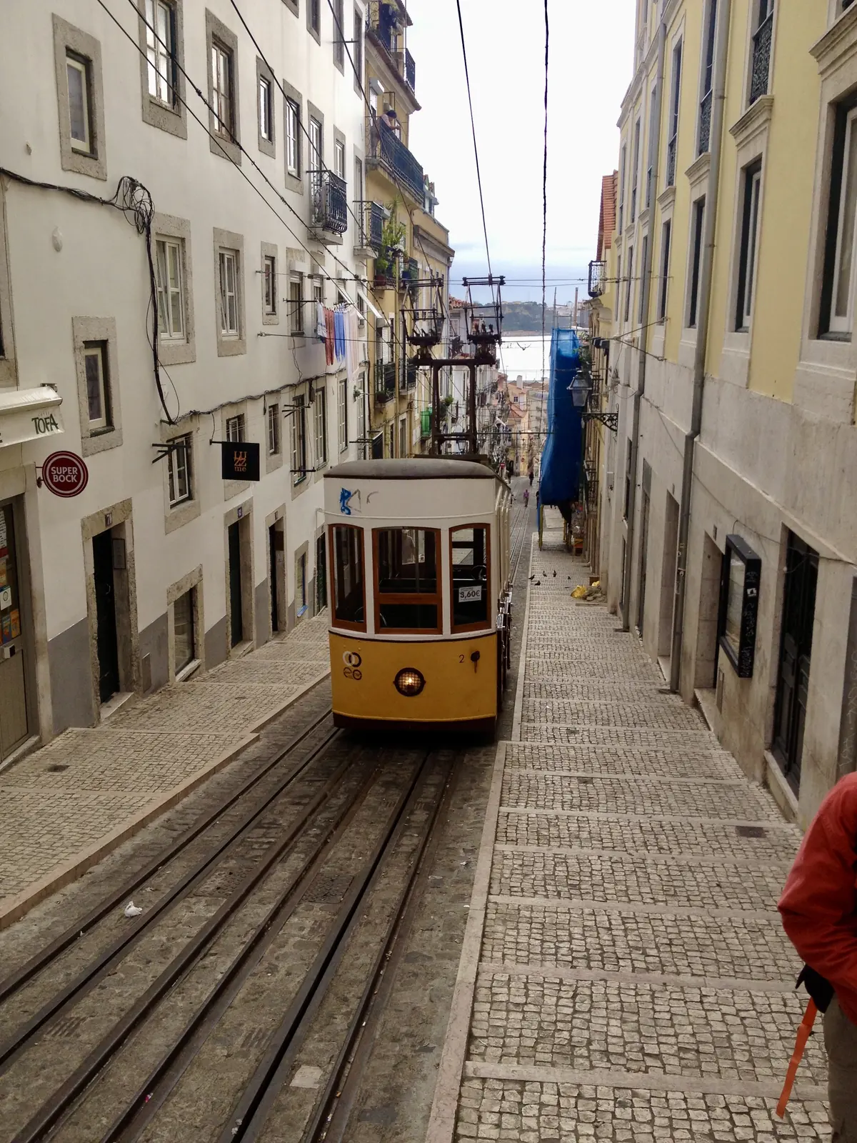 The yellow Elevador da Bica funicular on its steep street in Lisbon
