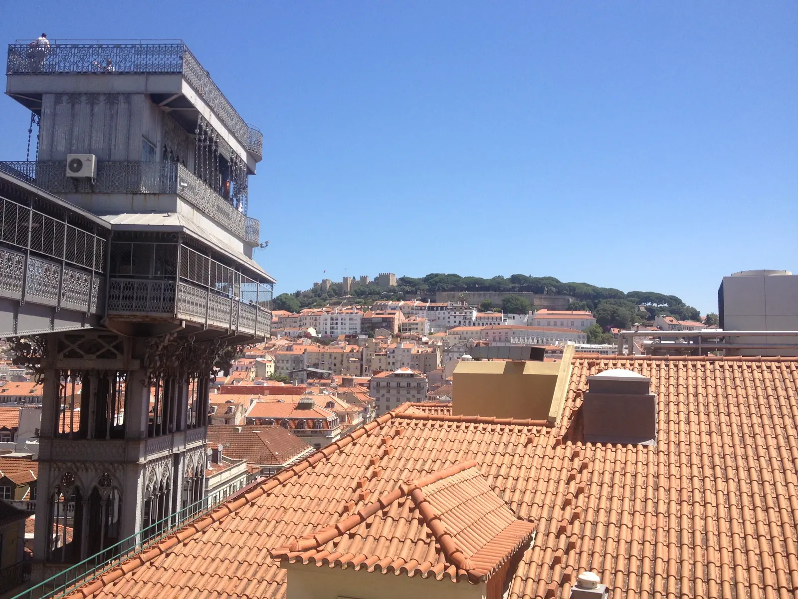 The Elevador de Santa Justa with the castle and the roofs of Lisbon behind
