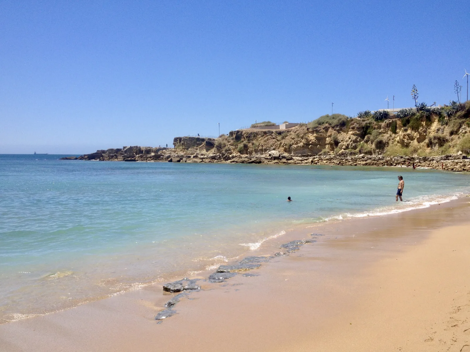 Turquoise water and golden sand on a beach in Estoril