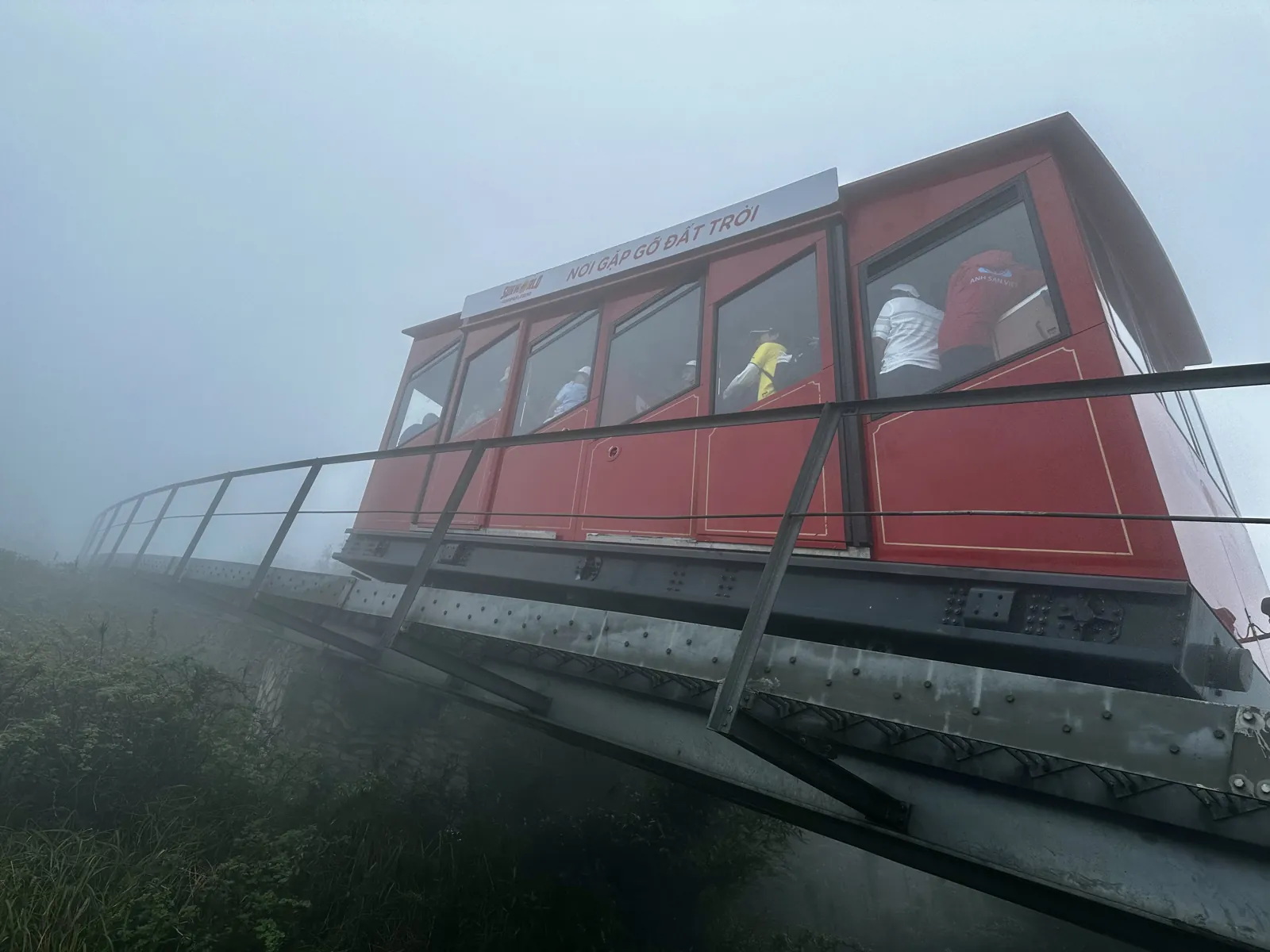 Rode kabelspoorweg naar de top van de Fansipan op zijn spoor in de mist