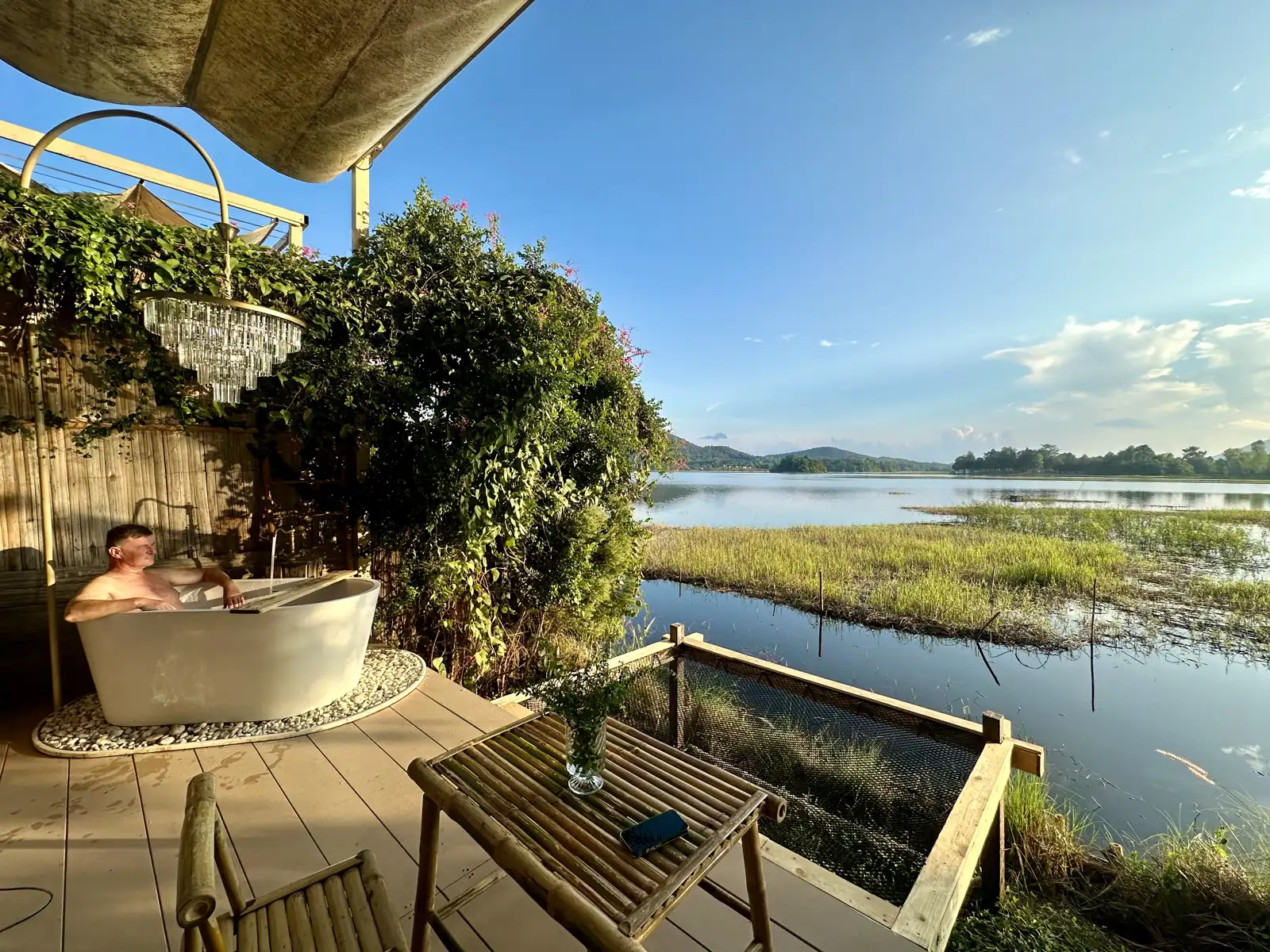Badkuip met uitzicht op het meer bij een glampingkoepel nabij Chiang Rai