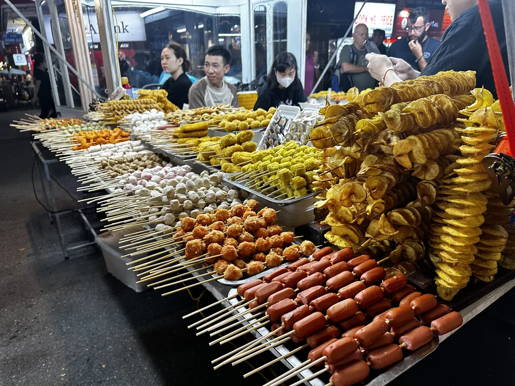 Gegrilde spiesjes bij een streetfoodkraam in Hanoi 's avonds