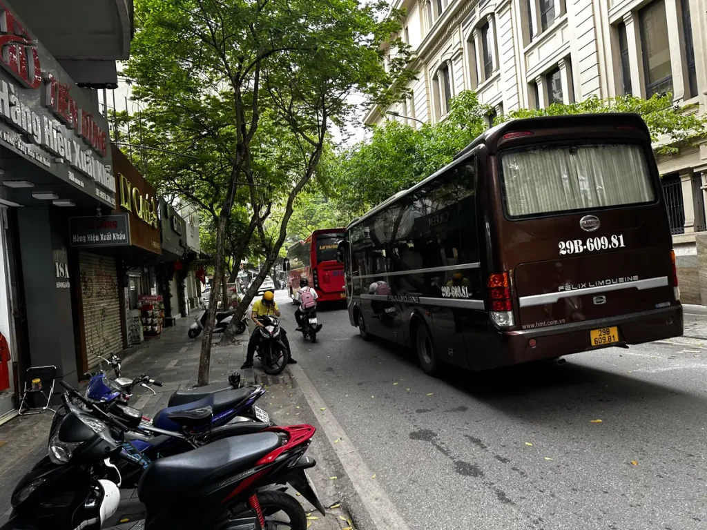 Limousinebus geparkeerd in een straat in Hoan Kiem voor vertrek uit Hanoi naar de Ha Long-baai
