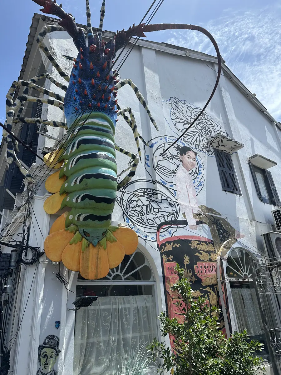 Reusachtig kreeftbeeld op een gevel met street art, oude stad van Phuket