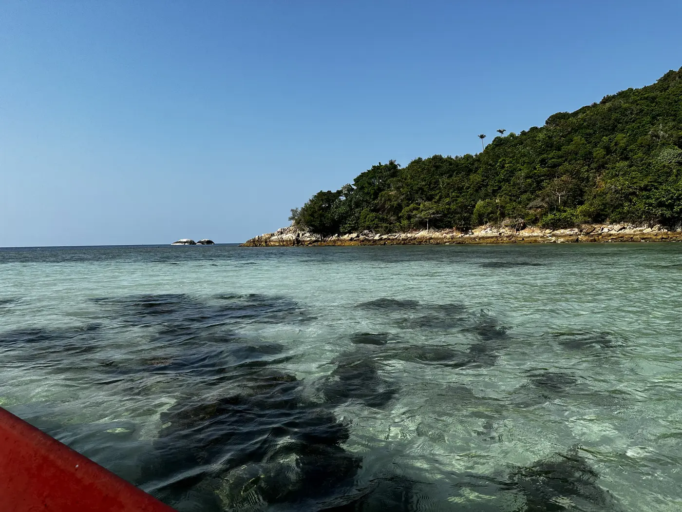 Agua cristalina y costa selvática vistas desde un barco longtail entre Chaloklum y Bottle Beach, Koh Phangan