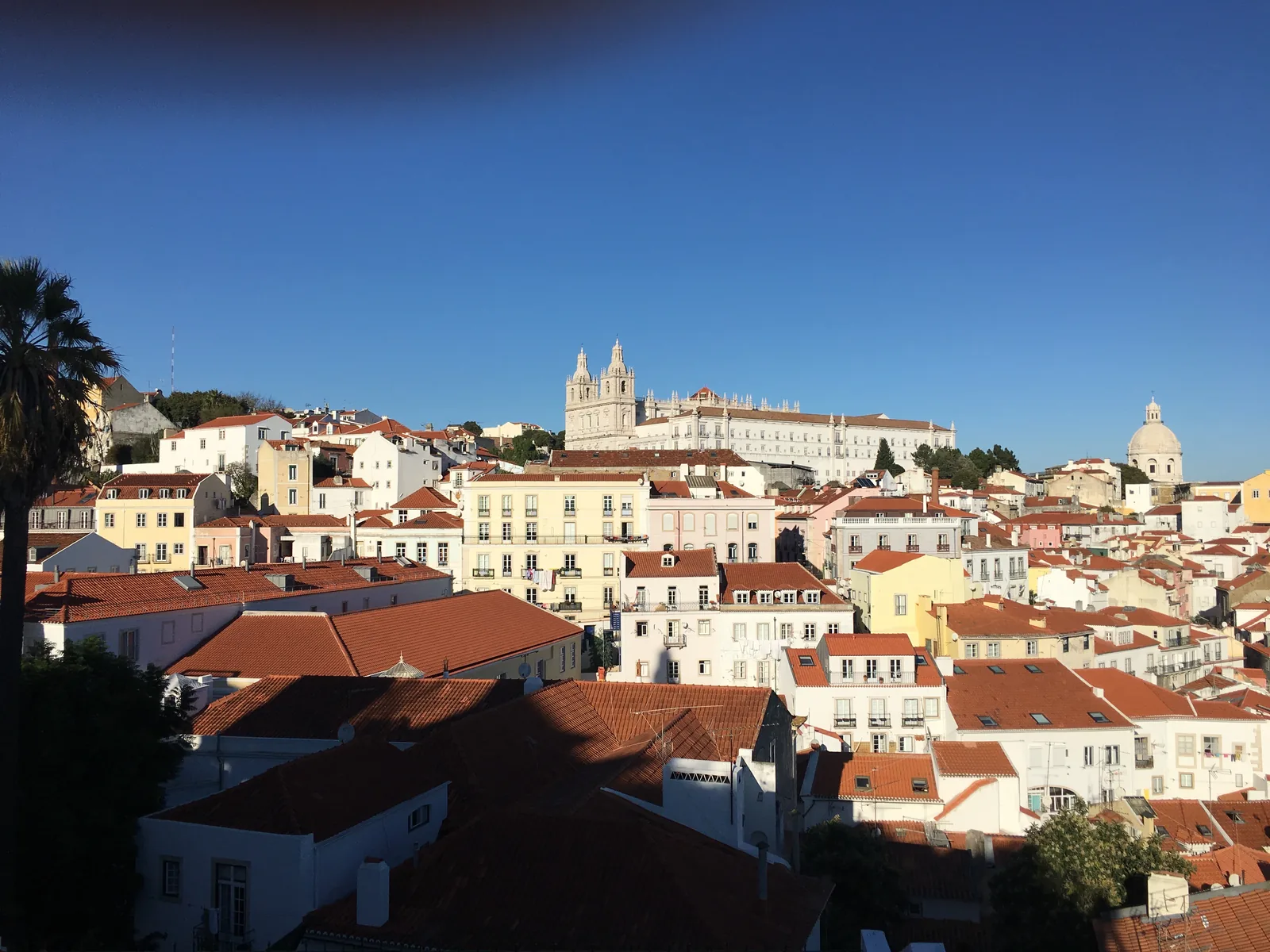 The white houses and red roofs of Alfama seen from the Miradouro das Portas do Sol
