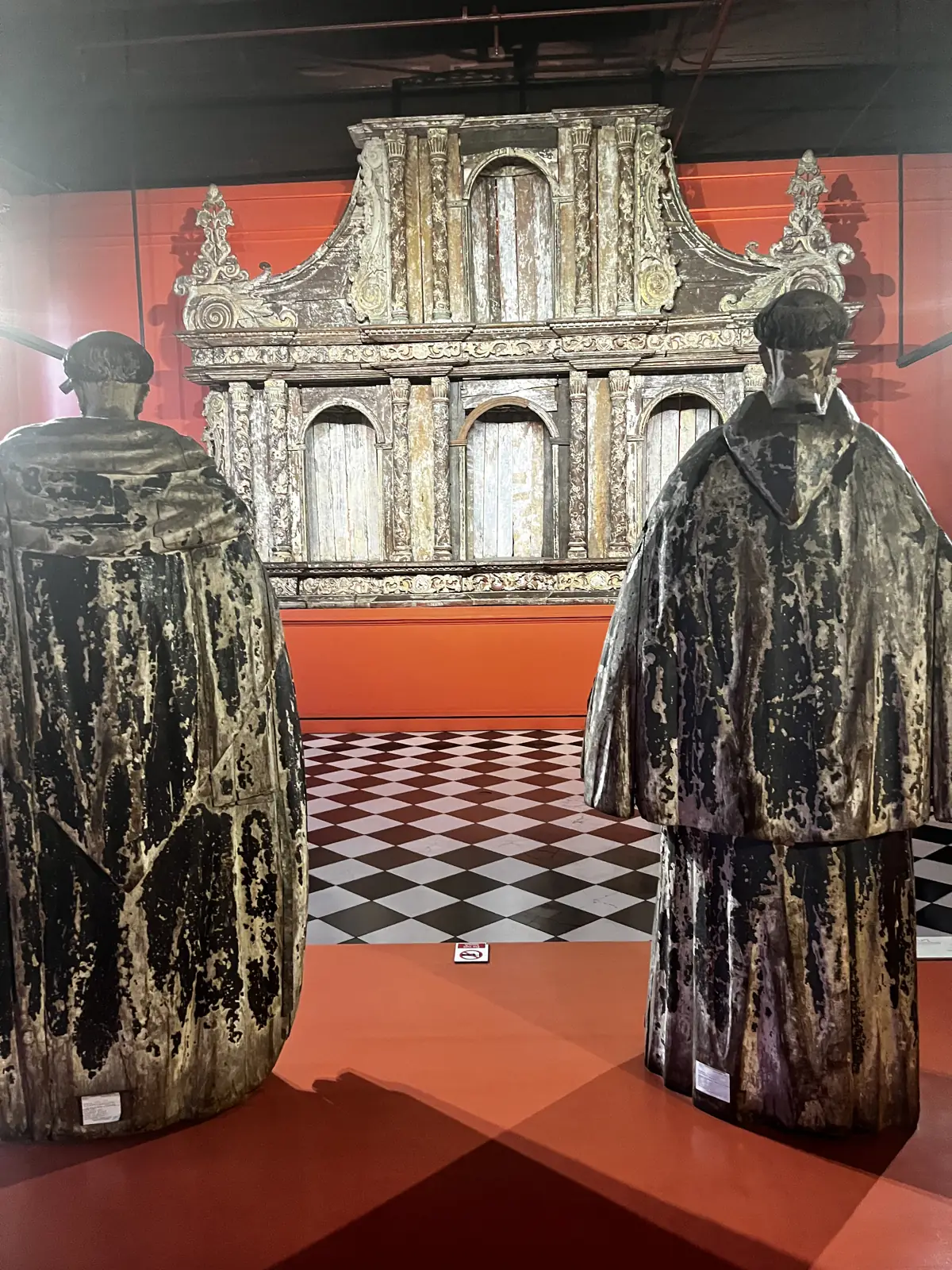 Statue di frati davanti a un retablo scolpito al National Museum di Manila
