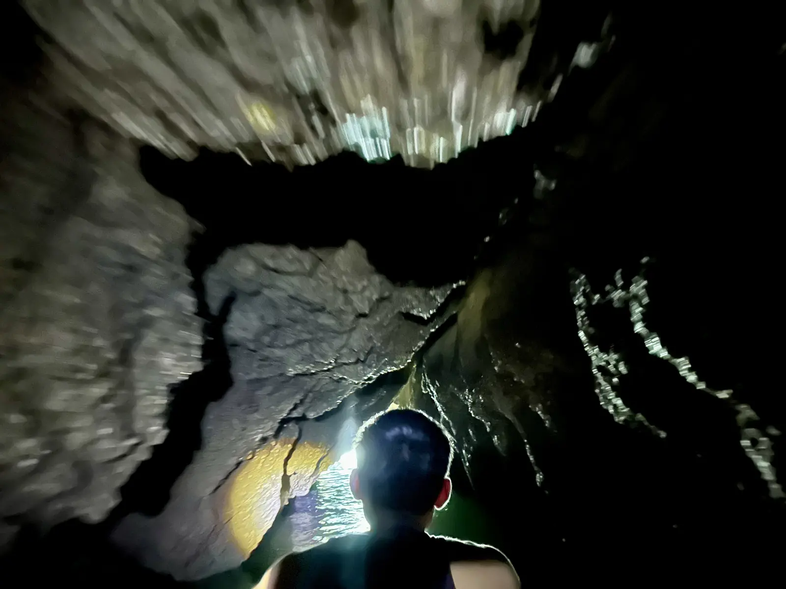 In kayak in una grotta marina completamente buia illuminata da una lampada frontale, Ko Panak, baia di Phang Nga